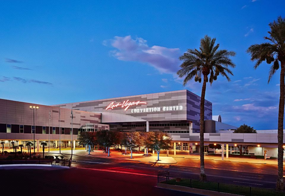 a large building with a large sign on top and palm trees in front of it at Courtyard by Marriott Las Vegas Convention Center
