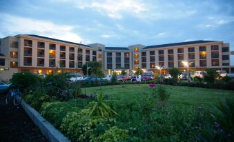 a large hotel building with a parking lot in front of it , surrounded by grass and trees at Haile Resort Hawassa
