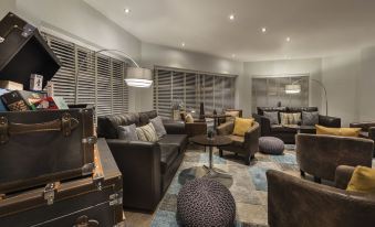 a spacious living room with a variety of seating options , including couches , chairs , and ottomans at Mode Hotel St Annes