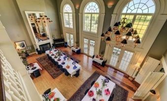 a large room with multiple tables and chairs set up for a formal dinner party at Claremont Inn & Winery