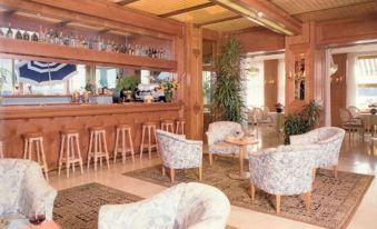 a well - decorated bar with several chairs and couches , creating a comfortable and inviting atmosphere for patrons at Hotel Milano