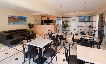 a restaurant with several tables and chairs , a bar area , and a tv on the wall at Sunrise Apartments