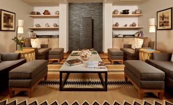 a modern living room with wooden furniture , a coffee table , and various decorative items on the shelves at The Blake at Taos Ski Valley