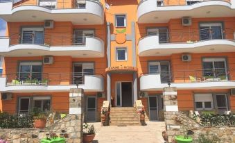 a large orange and white apartment building with multiple balconies and plants in front of it at Orange House