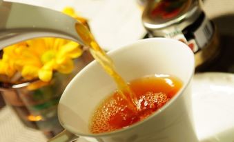 A cup and saucer are on the table, and hot tea is being poured into it at The Charterhouse Causeway Bay