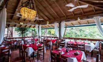 a large , well - lit restaurant with wooden tables and chairs arranged for a group of people to enjoy their meal at Altos de Cano Hondo