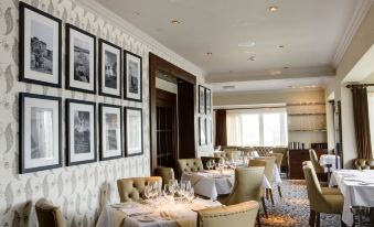 a well - decorated dining room with tables and chairs arranged for a group of people to enjoy a meal together at Trearddur Bay Hotel