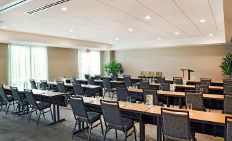 a large conference room with rows of tables and chairs , a podium , and a potted plant at Courtyard Yonkers Westchester County