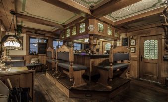 a room with wooden walls and ceiling , featuring two chairs and a dining table in the corner at Hotel Bellevue