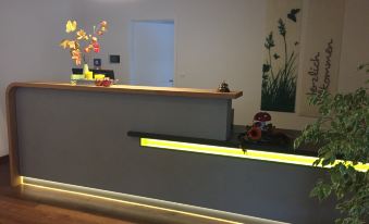 a modern office reception area with a wooden counter , potted plants , and a large painting on the wall at Loewen