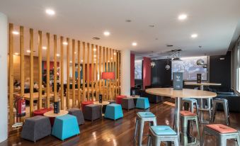 a modern restaurant with wooden floors , blue and gray seating areas , and a bar area at Stay Hotel Guimarães Centro