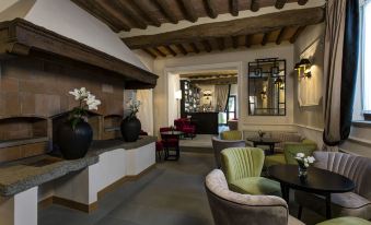 a modern hotel lobby with various seating options , including couches and chairs , as well as potted plants and a bar at Villa le Calvane