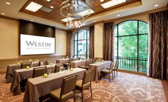 a conference room set up for a meeting , with chairs arranged in rows and a projector on the wall at Dossier