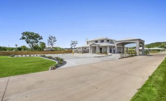 a modern , white house with a large driveway and grassy area in front of it at Casa Nostra Motel
