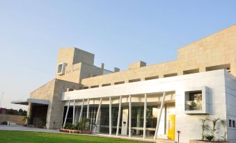 a modern building with a large glass window and a grassy area in front of it at The Opal