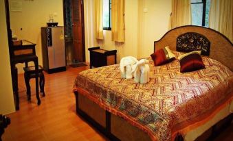 a well - decorated hotel room with a large bed , a tv , and a refrigerator in the background at Phufatara Resort