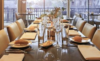 a long dining table set for a formal meal , with multiple place settings and utensils arranged neatly at Novotel Swan Valley Vines Resort