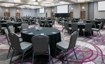 a large conference room with multiple round tables and chairs arranged for a meeting or event at Courtyard Omaha Bellevue at Beardmore Event Center