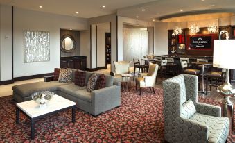 a spacious living room with various seating arrangements , including couches , chairs , and a dining table at Residence Inn by Marriott Boston Needham