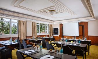 a conference room with chairs arranged in rows and a projector screen on the wall at Melia Purosani Yogyakarta