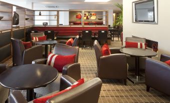 a well - lit restaurant with several dining tables and chairs , creating a pleasant atmosphere for guests at Holiday Inn Express Milton Keynes