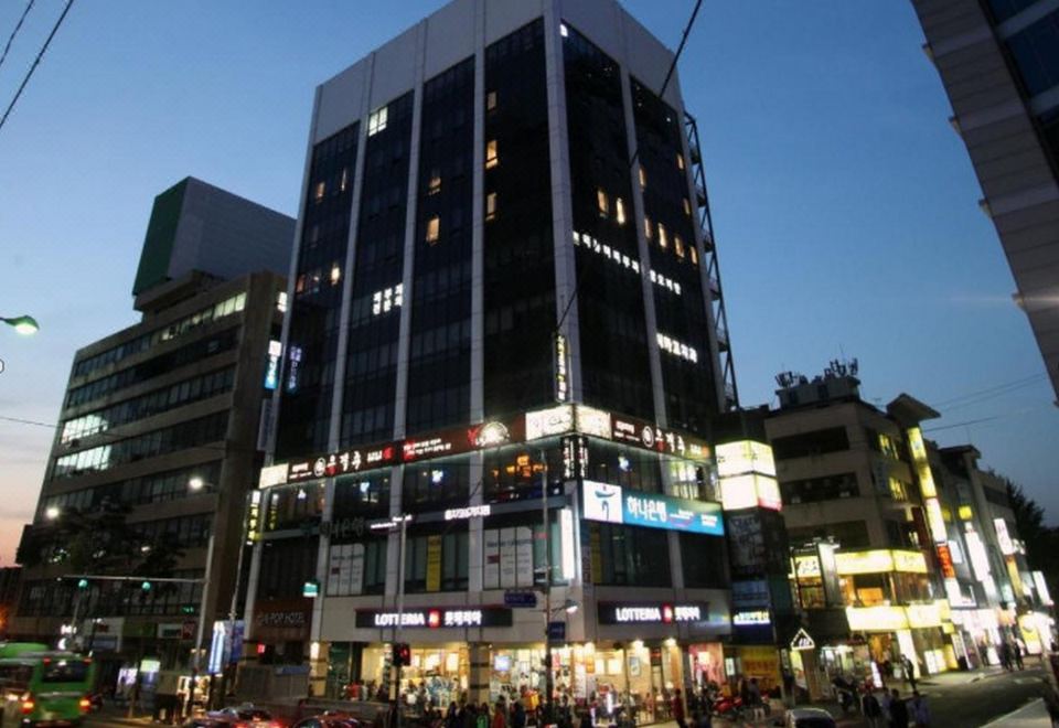 A photo of a large building with cars parked in front on the street at night at KSTAR METRO Hotel