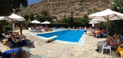 a large outdoor swimming pool surrounded by lounge chairs and umbrellas , providing a relaxing atmosphere for people to enjoy at Valley Village