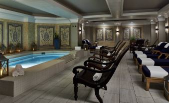 a large indoor pool area with several chairs arranged around the pool , creating a relaxing atmosphere at The Grand Hotel Golf Resort & Spa, Autograph Collection