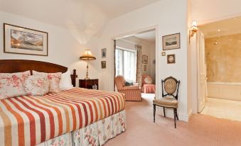The suite includes a spacious bedroom with an en-suite bathroom and a connected sitting area at Sharrow Bay Country House Hotel