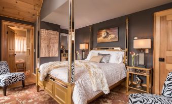 a luxurious bedroom with a four - poster bed in the center of the room , surrounded by various pieces of furniture and decorations at Gothic Eves Inn and Spa Bed and Breakfast
