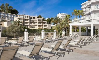 a large outdoor pool area with several lounge chairs and umbrellas , providing a relaxing atmosphere for guests at Globales Palmanova