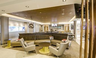 a modern hotel lobby with a bar , seating area , and a pool table , all decorated in neutral colors at SpringHill Suites Dayton Vandalia