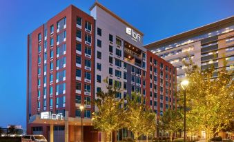"a large building with a sign that says "" all hotel "" is surrounded by trees and bushes" at Aloft Richardson