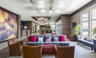 a hotel lobby with a large couch and chairs , creating a comfortable seating area for guests at Four Points by Sheraton Chicago O'Hare