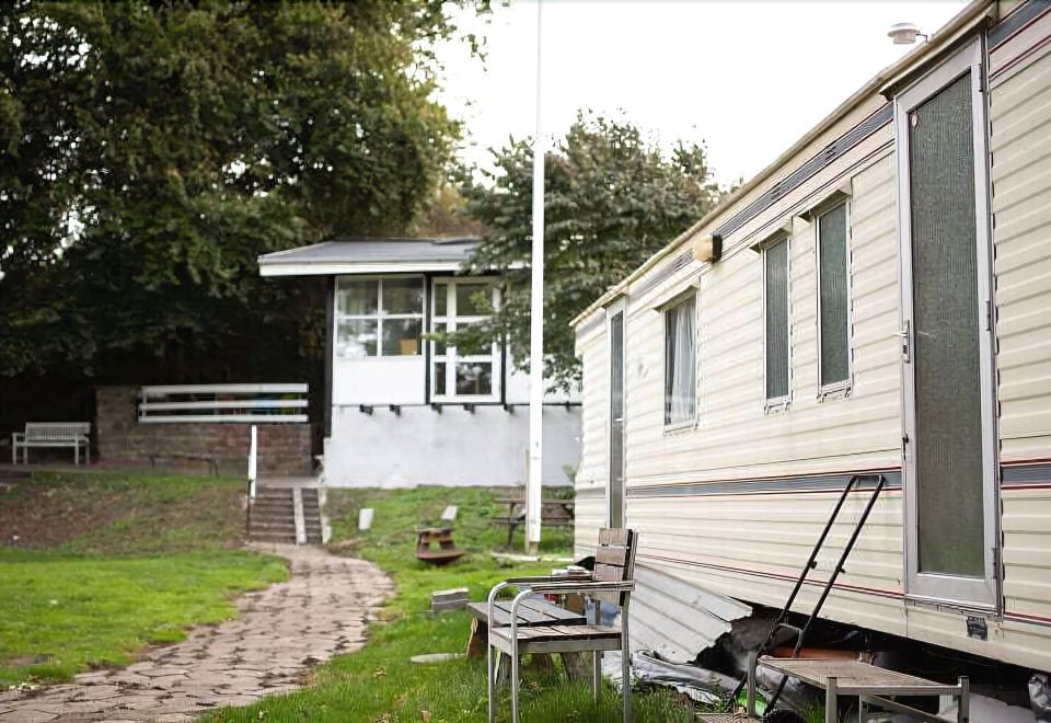 a white house is situated next to a house with a tree in the yard at Paradiset