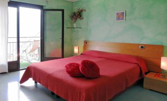 a bedroom with a large bed , red blanket , and two pillows on the foot of the bed at Bellavista