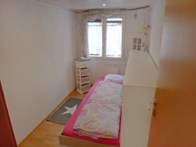 a small bedroom with a bed , a window , and a rug on the floor at Marilyn Visperterminen