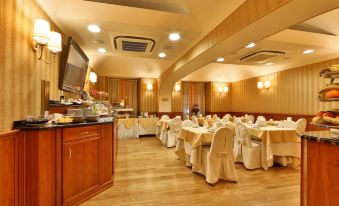 a large dining room with tables and chairs arranged for a group of people to enjoy a meal together at Phi Hotel Principe