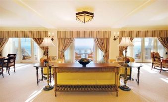 a large , open room with a wooden table and chairs , lamps on either side , and curtains covering the windows at Montage Laguna Beach
