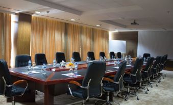 A spacious conference room with a long table and black chairs is available for meetings or boardroom use at Sayeman Beach Resort
