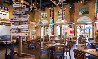 a restaurant with wooden tables and chairs , large windows , and directional signs on the walls at Hyatt Regency Huntington Beach Resort and Spa