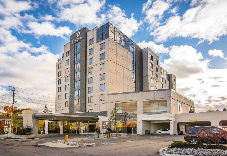 "a large building with a sign that reads "" hilton hotel "" is surrounded by a parking lot" at Delta Hotels by Marriott Waterloo