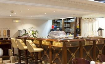 a restaurant with a wooden bar and several stools , providing seating for guests to sit and enjoy their meals at Napoleon