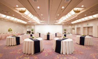 a large conference room with several round tables and chairs set up for a meeting or event at Kawasaki Nikko Hotel