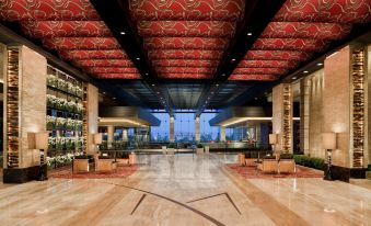 a large , open room with wooden floors and red ceiling panels is filled with shelves of bottles at M Resort Spa & Casino
