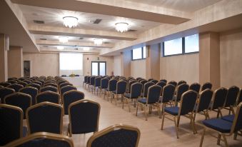 a large conference room with rows of blue and gold chairs arranged in a semicircle at Libyan Princess