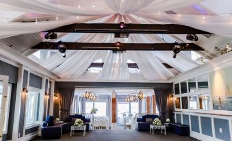 a large room with high ceilings and white drapes , creating an elegant and luxurious atmosphere at Danfords Hotel & Marina