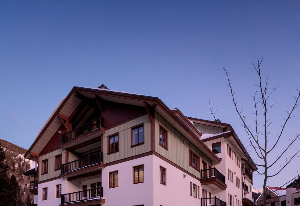 a large white building with many windows and balconies is situated in a snowy area at The Blake at Taos Ski Valley