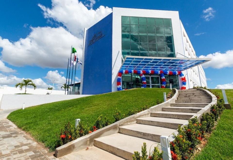 a modern building with a blue facade and a green roof , surrounded by green grass and trees at Bristol Aline