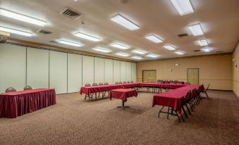 a large , empty conference room with multiple rows of red chairs arranged in an orderly fashion at Quality Inn